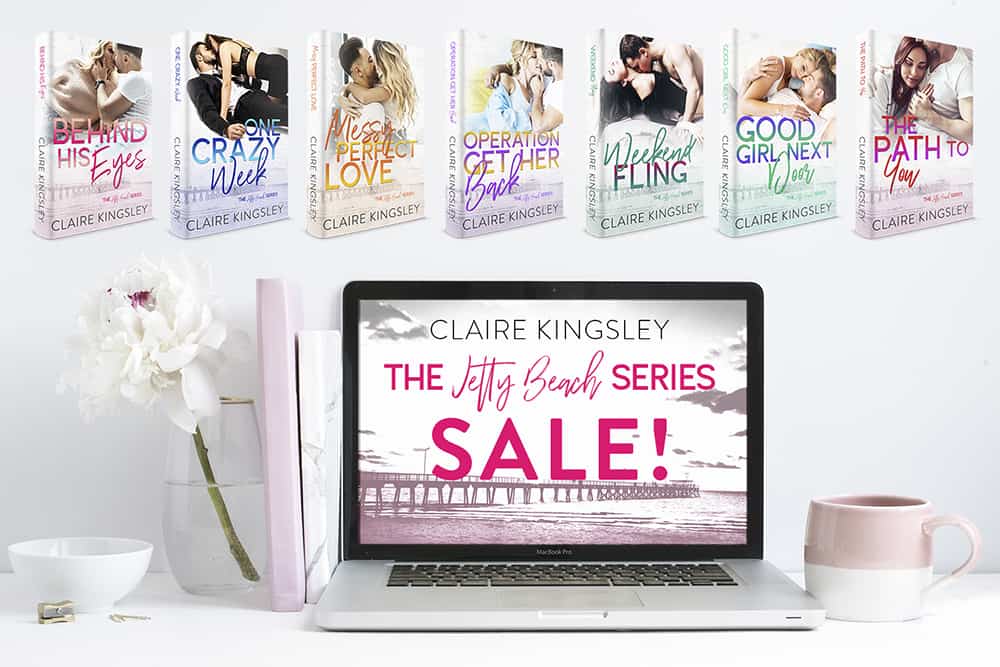 Seven paperbacks. Each displays one of the seven book covers for the Jetty Beach series. An open laptop screen next to a coffee mug and a vase with a single white flower, the laptop screen says "Claire Kingsley, The Jetty Beach Series Sale!".