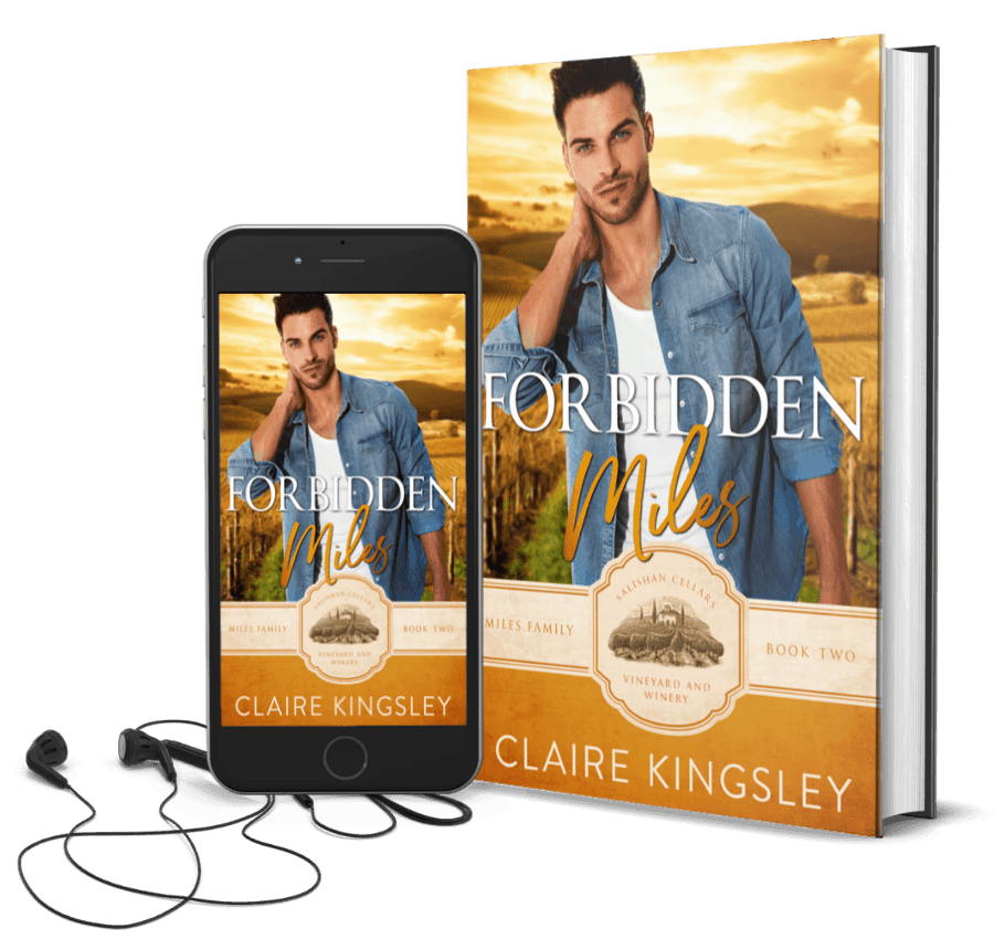 The book cover for Forbidden Miles, a small-town romance by Claire Kingsley, is an image of a dark haired man standing with one hand resting on the back of his neck and a small smirk on his face, a vineyard at sunset in the background. There are shades of yellow and white. Next to the book is a phone showing the cover with a pair of wired earbuds.