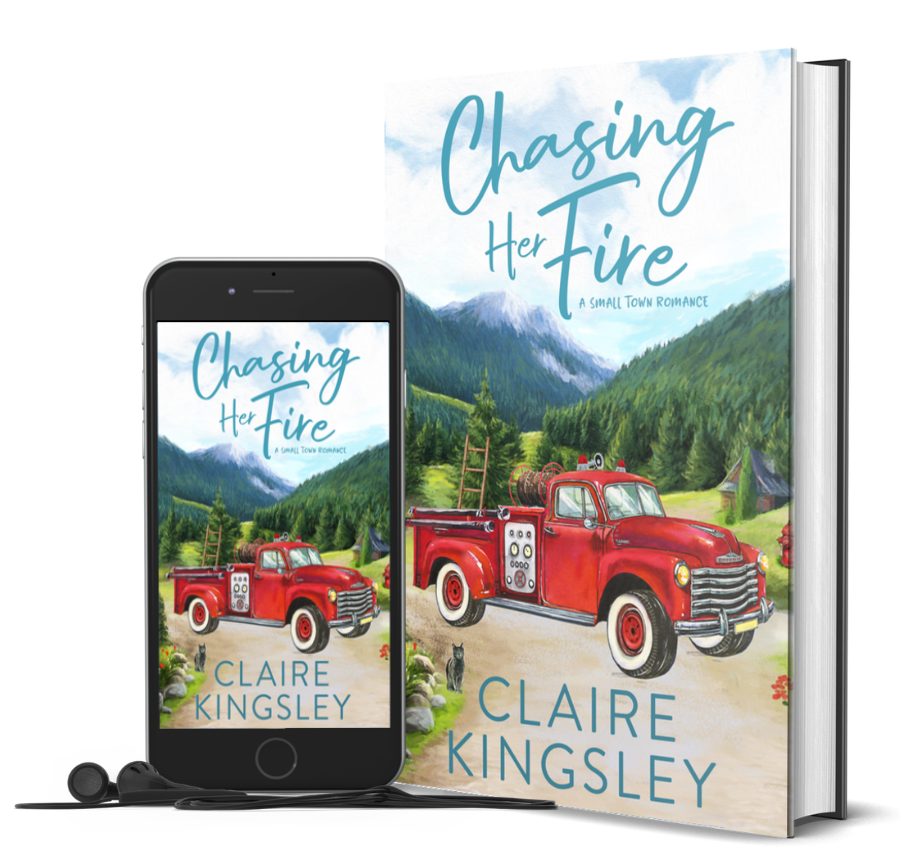 The book cover for Chasing Her Fire, a small-town romance by Claire Kingsley, is an illustrated image of an old red fire truck parked on a dirt road with a forest of pine trees and a mountain in the background. Next to the book is a phone showing the cover with a pair of wired earbuds.