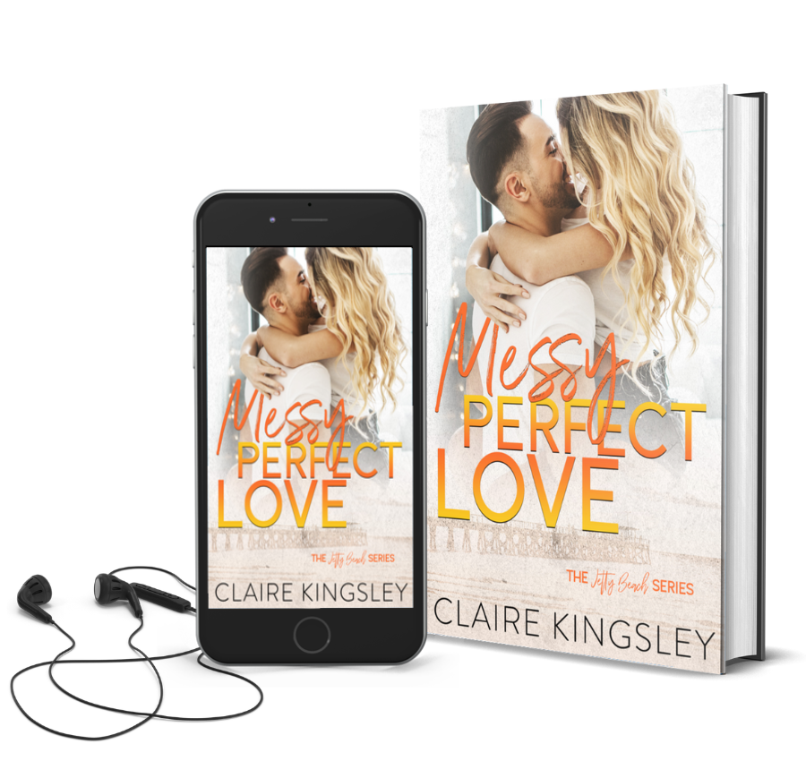 The book cover for Messy Perfect Love, a small-town romance by Claire Kingsley, is an image of a woman with blonde curly hair being held by a man with dark hair and a beard while her arms are wrapped around his shoulders, their faces leaned in close together as they both laugh. There are shades of orange and yellow. Next to the book is a phone showing the cover with a pair of wired earbuds.