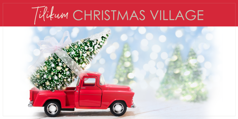 A model of an old red pickup truck with a Christmas tree in the bed. Text reads "Tilikum Christmas Village."